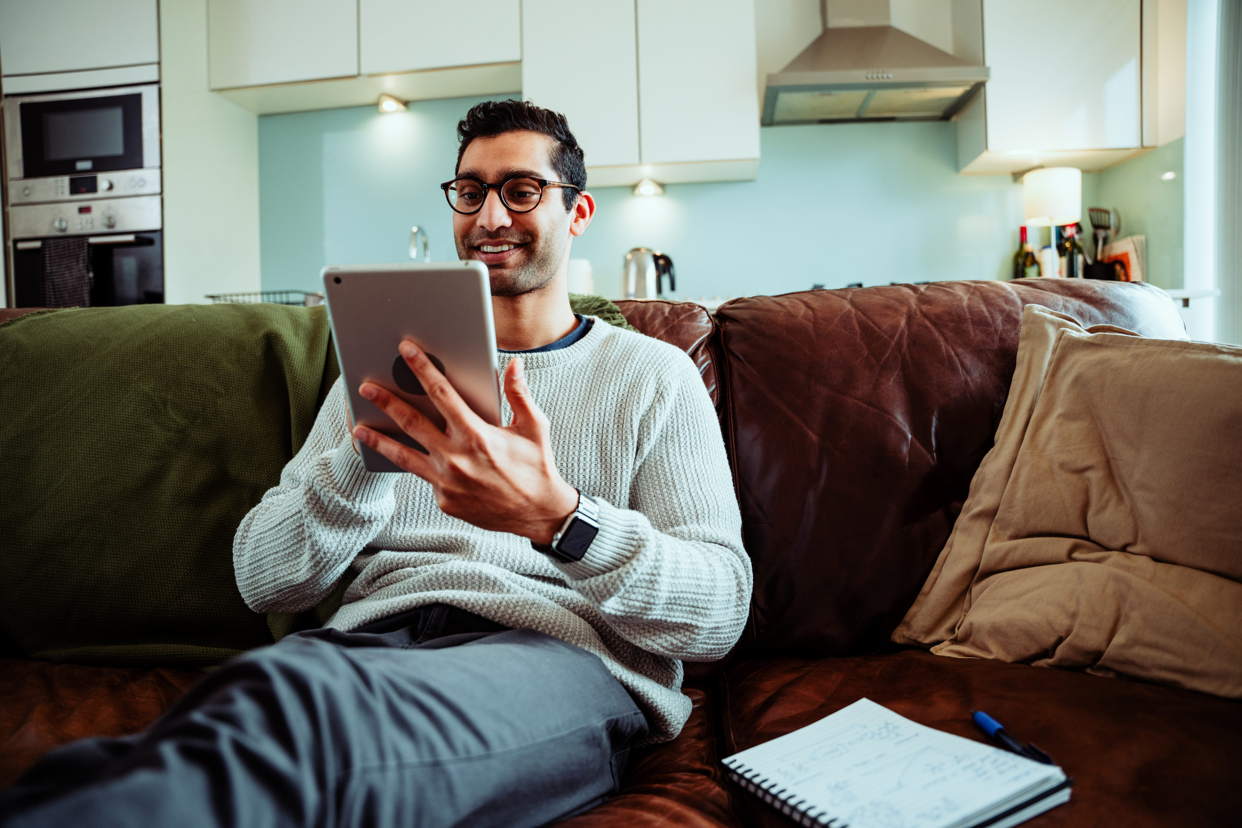 Man sitting on couch using his tablet
