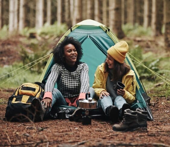Laughing group of diverse young female friends waking up after a night camping in the forest. eBay trends