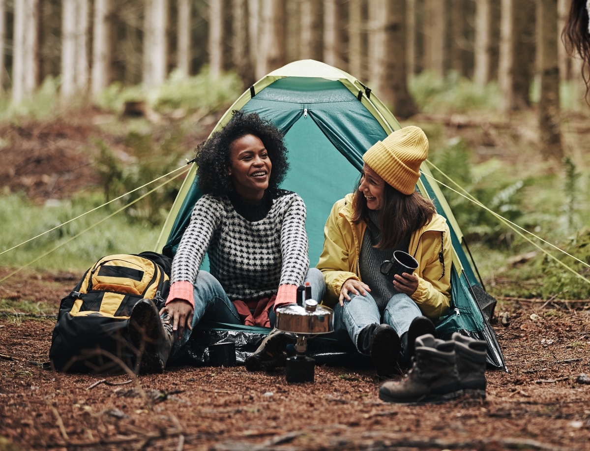 Laughing group of diverse young female friends waking up after a night camping in the forest. eBay trends